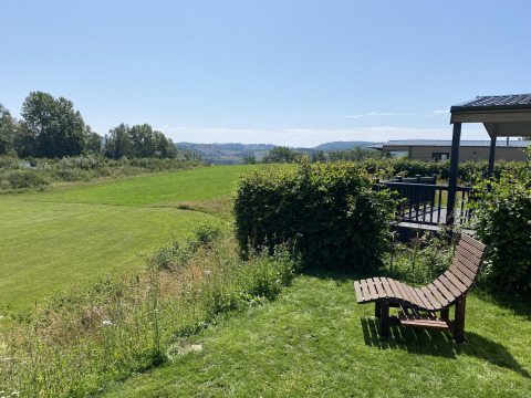 Día soleado en Chalet Waldfee en Camping & Ferienpark Brilon, Alemania, con vistas a campos y colinas verdes.