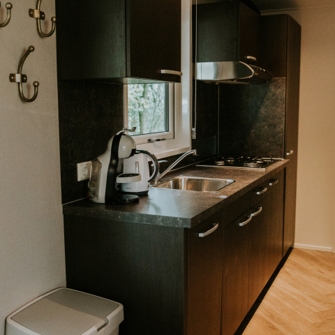 Cocina moderna en Happy Bee Lodge, Camping Si-Es-An, Países Bajos, con hervidor y fregadero.