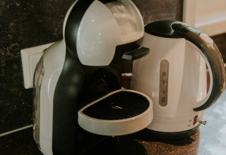 Waterkoker en koffiemachine op het aanrecht in Happy Bee Lodge, Camping Si-Es-An, Nederland.