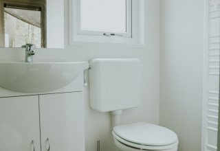 Modernes Badezimmer mit Toilette und Waschbecken in der Happy Bee Lodge, Camping Si-Es-An, Niederlande.