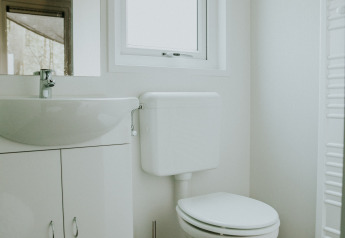 Bagno moderno e luminoso con WC e lavandino presso Happy Bee Lodge, Camping Si-Es-An nei Paesi Bassi.