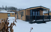 Cabañas de madera cubiertas de nieve en Chalet Bergrose, Camping & Ferienpark Brilon, Alemania, en invierno.