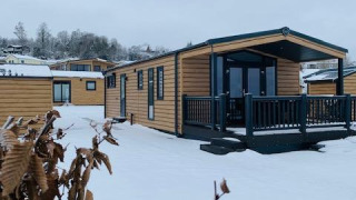 Baite di legno innevate presso Chalet Bergrose, Camping & Ferienpark Brilon, Germania, in una giornata invernale.