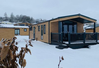 Cabañas de madera cubiertas de nieve en Chalet Bergrose, Camping & Ferienpark Brilon, Alemania, en invierno.