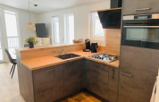 Cucina moderna con piano in legno, forno e grandi finestre presso Chalet Bergrose, Camping Brilon, Germania.