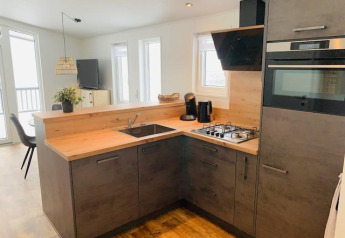 Cuisine moderne du Chalet Bergrose avec comptoir en bois, plaques de cuisson et fenêtres lumineuses en Allemagne.