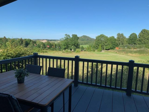 Vista desde Chalet Bergrose en Camping & Ferienpark Brilon, Alemania, con terraza y campos verdes.