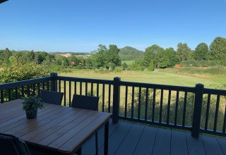 Vista desde Chalet Bergrose en Camping & Ferienpark Brilon, Alemania, con terraza y campos verdes.