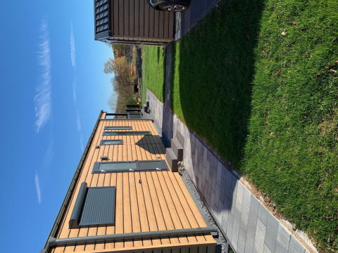 Cabaña de madera en Chalet Bergrose, Camping & Ferienpark Brilon, Alemania, césped y sol.