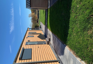 Cabaña de madera en Chalet Bergrose, Camping & Ferienpark Brilon, Alemania, césped y sol.