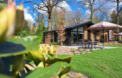 Lodge Hackfort 4 moderno en De Utrechtse Heuvelrug, Países Bajos, rodeado de bosque, césped y terraza.