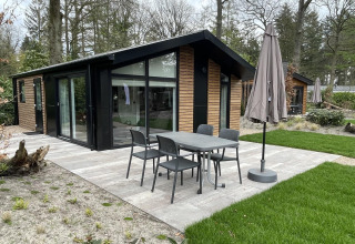 Moderne lodge Hackfort 4 aan De Utrechtse Heuvelrug in Nederland met terras, tuin en tuinmeubilair.