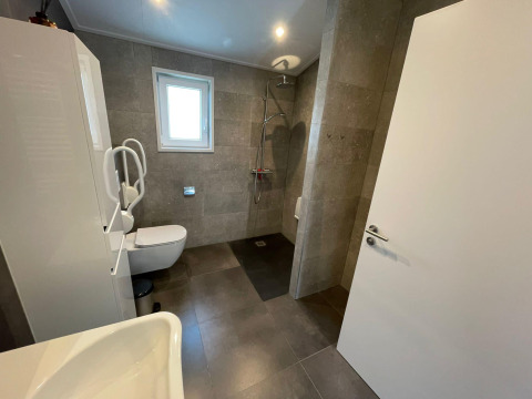 Baño accesible con ducha, inodoro y barras de apoyo en Hackfort MIVA, De Utrechtse Heuvelrug, Países Bajos.