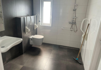 Toegankelijke badkamer in Hackfort MIVA, De Utrechtse Heuvelrug, Nederland, met handgrepen en hulpmiddelen.
