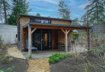Tiny house moderne en bois avec terrasse couverte, mobilier extérieur, à Beekbergen, Pays-Bas, en forêt.