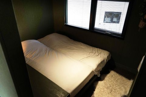 Schlafzimmer mit Doppelbett und Teppich im Tiny House 4 Hottub in Beekbergen, Niederlande.