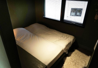 Camera da letto con letto matrimoniale e finestra nella Tiny House 4 Hottub a Beekbergen, Paesi Bassi.