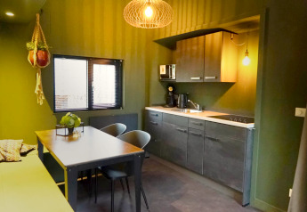 Moderne lille køkken og spiseplads i Tiny House 4 Hottub, Beekbergen, Holland, med grønne vægge.