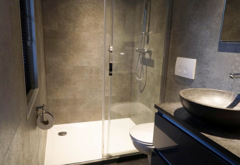 Modernes kleines Badezimmer mit Dusche, WC, Waschbecken und grauen Fliesen im Tiny House 4 Hottub, Beekbergen.