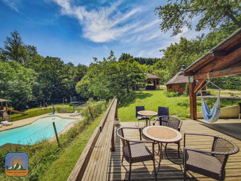 Camping Des Randonneurs in Occitanie, France, featuring a pool, terrace seating, hammock, and lush scenery.