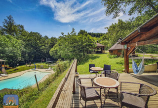 Camping Des Randonneurs in Occitanie, France, featuring a pool, terrace seating, hammock, and lush scenery.