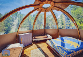 Interior de una exclusiva tienda burbuja sin fontanería en Camping Des Randonneurs, rodeada de bosque en Francia.