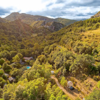 Vista aérea del paisaje montañoso y verde cerca de Fenouillet, Occitanie, Francia, con cabañas entre los árboles.