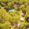 Aerial view of Camping Des Randonneurs holiday park in Occitanie, France, showing pool, cabins and trees.