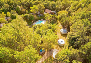 Luchtfoto van Camping Des Randonneurs in Occitanië, Frankrijk, met zwembad, huisjes en bosrijke omgeving.