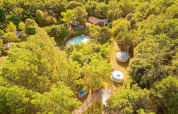 Aerial view of Camping Des Randonneurs holiday park in Occitanie, France, showing pool, cabins and trees.