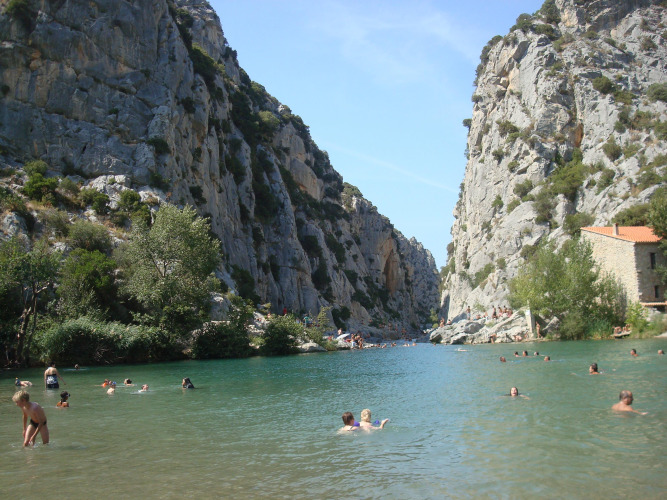 Vakantiepark Camping Des Randonneurs in Occitanië, Frankrijk, met zwemmers in een rivier tussen rotswanden.