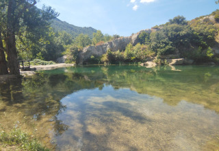 View of clear water and green surroundings at Camping Des Randonneurs, Occitanie, France holiday park.
