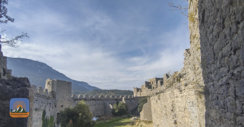 Vista delle mura di una fortezza medievale vicino a Fenouillet, Occitania, Francia, con montagne sullo sfondo.
