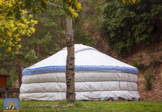 Tienda yurta XL sin baño privado en Camping Des Randonneurs, Francia, rodeada de naturaleza y árboles.