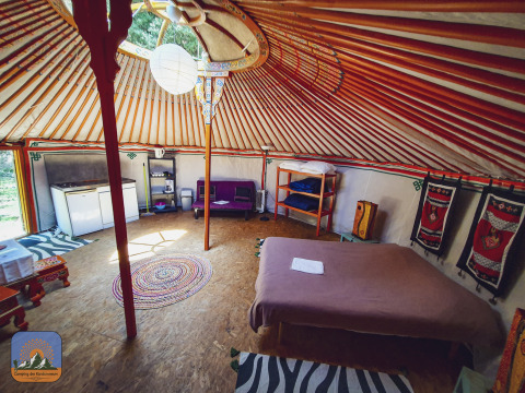 Interior of XL yurt tent without private bathroom at Camping Des Randonneurs in France, cozy and inviting setting.