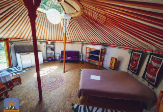 Interior of XL yurt tent without private bathroom at Camping Des Randonneurs in France, cozy and inviting setting.