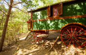 Carro gitano senza bagno privato nei boschi al Camping Des Randonneurs, Francia, con area salotto esterna.