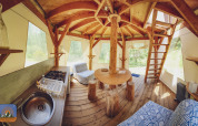 Inde i en unik boble-tipi med træmøbler og tekøkken på Camping Des Randonneurs, omgivet af natur i Frankrig.