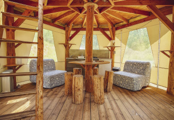 Interiør af en unik tipi-lignende boble uden VVS på Camping Des Randonneurs i Frankrig, med naturligt trædesign.