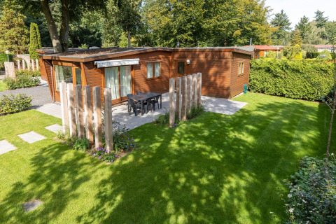 Petit chalet en bois confortable avec terrasse et jardin, situé à Bungalowpark Het Verscholen Dorp aux Pays-Bas.