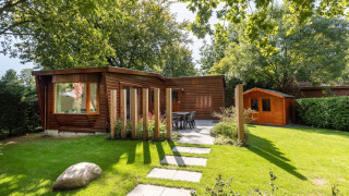 Chalet in legno e giardino con arredo esterno al Bungalowpark Het Verscholen Dorp, Paesi Bassi.