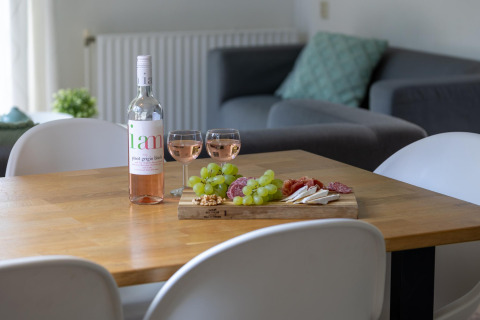 Wein und Tapas auf Holztisch in gemütlichem Haus, Cozy Chalet, Bungalowpark Het Verscholen Dorp, Niederlande.