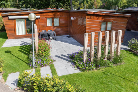 Acogedor chalet en Bungalowpark Het Verscholen Dorp, Países Bajos, con patio, jardín y fachada de madera.