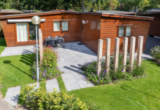 Acogedor chalet en Bungalowpark Het Verscholen Dorp, Países Bajos, con patio, jardín y fachada de madera.