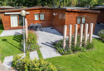 Udsigt over Cozy Chalet ved Bungalowpark Het Verscholen Dorp i Holland med træfacade og have.