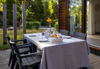 Tavola apparecchiata all'aperto al Cozy Chalet nel Bungalowpark Het Verscholen Dorp, Paesi Bassi, per colazione.