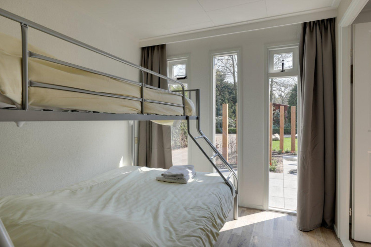 Habitación luminosa con litera y grandes ventanas en el Cozy Chalet de Bungalowpark Het Verscholen Dorp, Países Bajos.