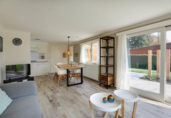 Helles, modernes Wohnzimmer im Cozy Chalet, Bungalowpark Het Verscholen Dorp, mit großen Fenstern und Esstisch.