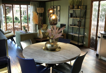 Moderne leef- en eetkamer in Cozy Chalet, Bungalowpark Het Verscholen Dorp, Nederland, met houten accenten.