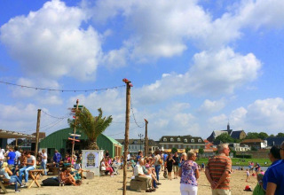 Personas disfrutan al aire libre en Cozy Chalet, Bungalowpark Het Verscholen Dorp, bajo el cielo azul de los Países Bajos.